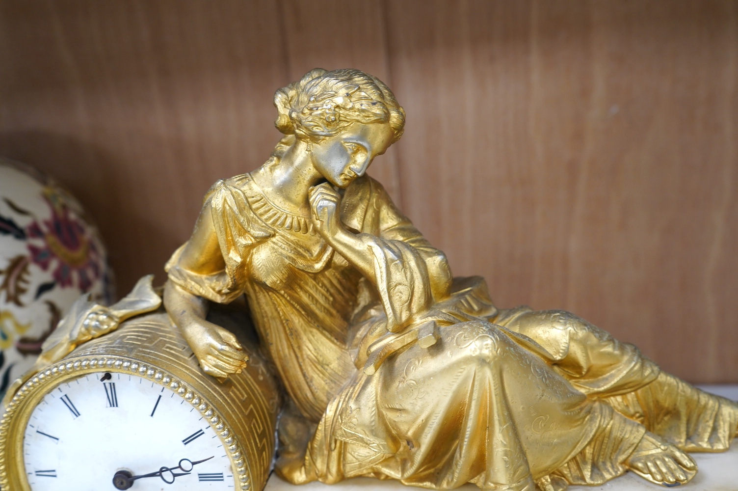 A 19th century white marble mantel clock with enamel dial, surmounted with a gilt spelter figure, with key, 46cm wide. Condition - fair, untested